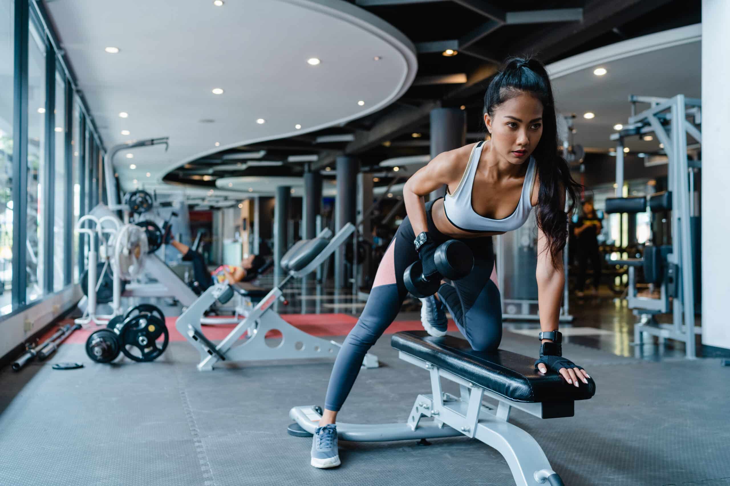 Woman doing dumbbell rows in the gym