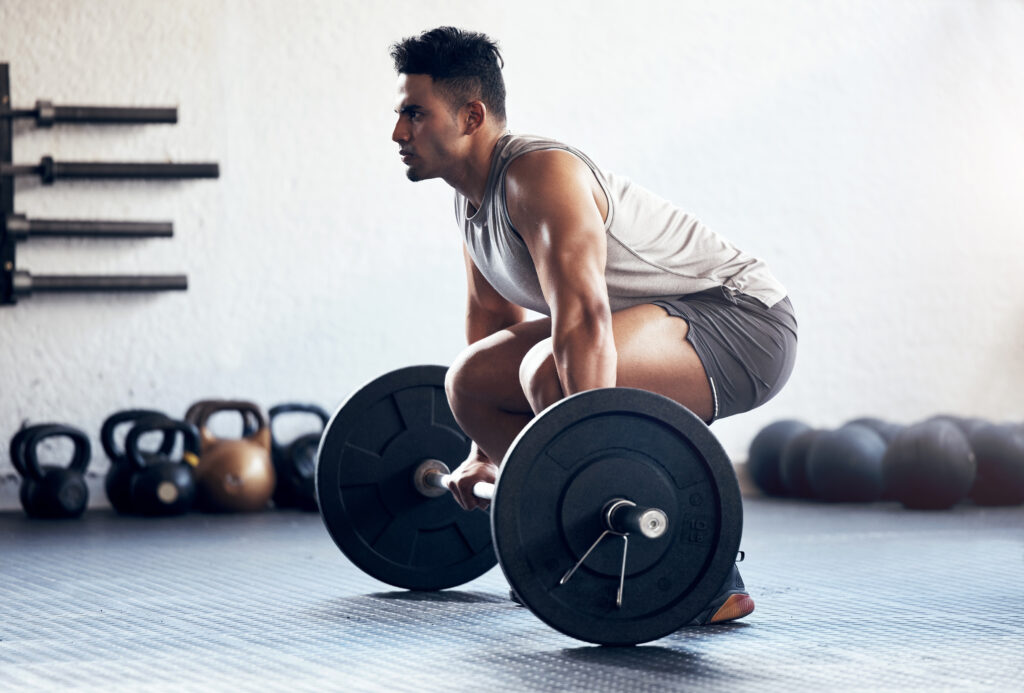 Man crouched about to do a barbell clean exercise in the gym