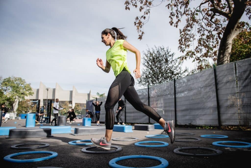 woman jumping into rings in an outdoor gym