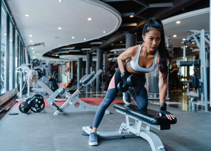 Woman doing dumbbell rows in the gym