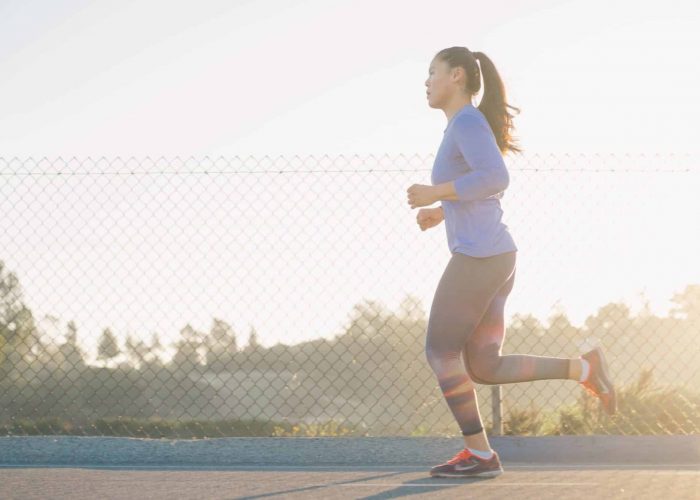 woman jogging down the street in early morning